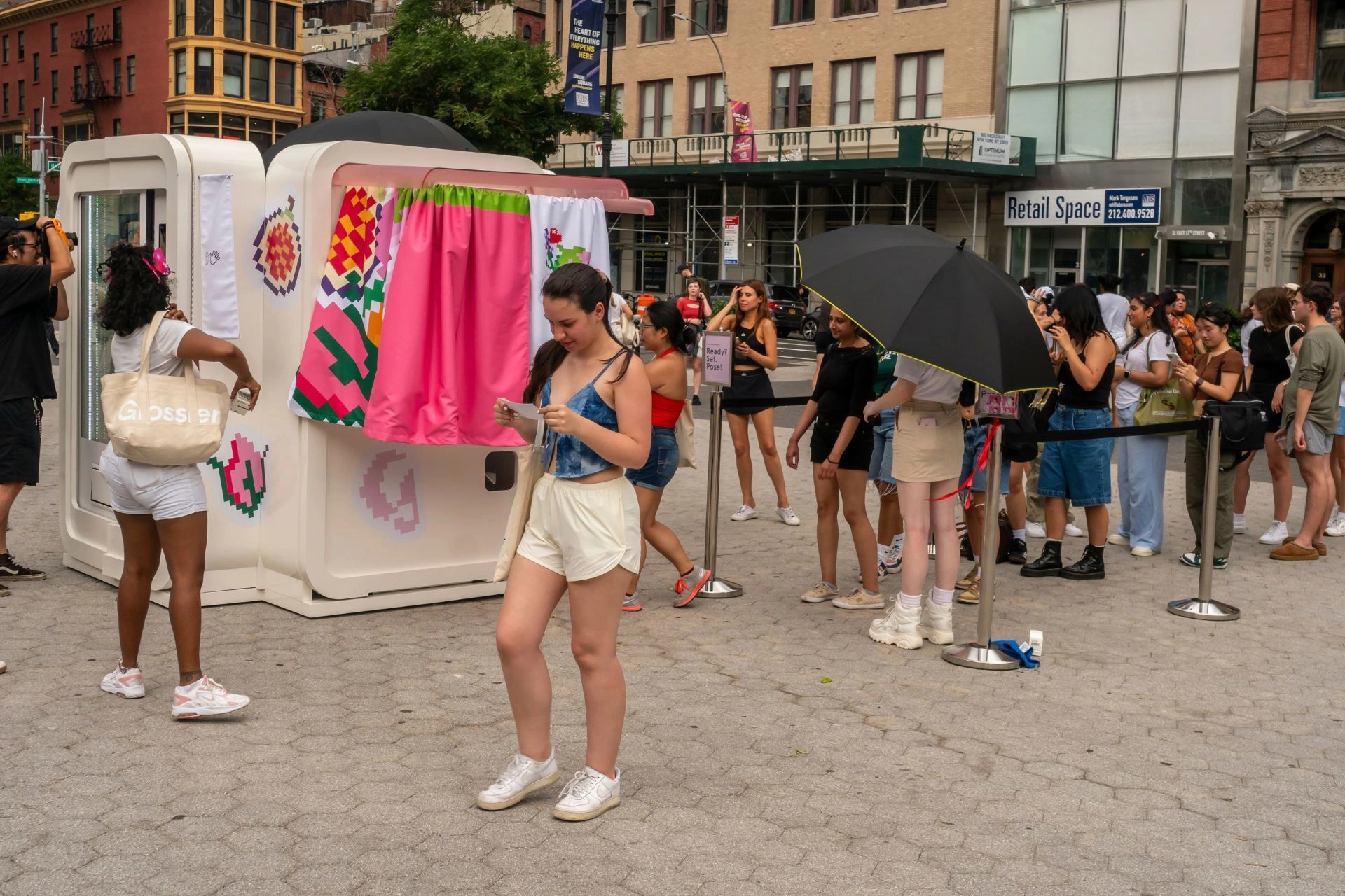People lining up for a Glossier brand activation pop-up booth
