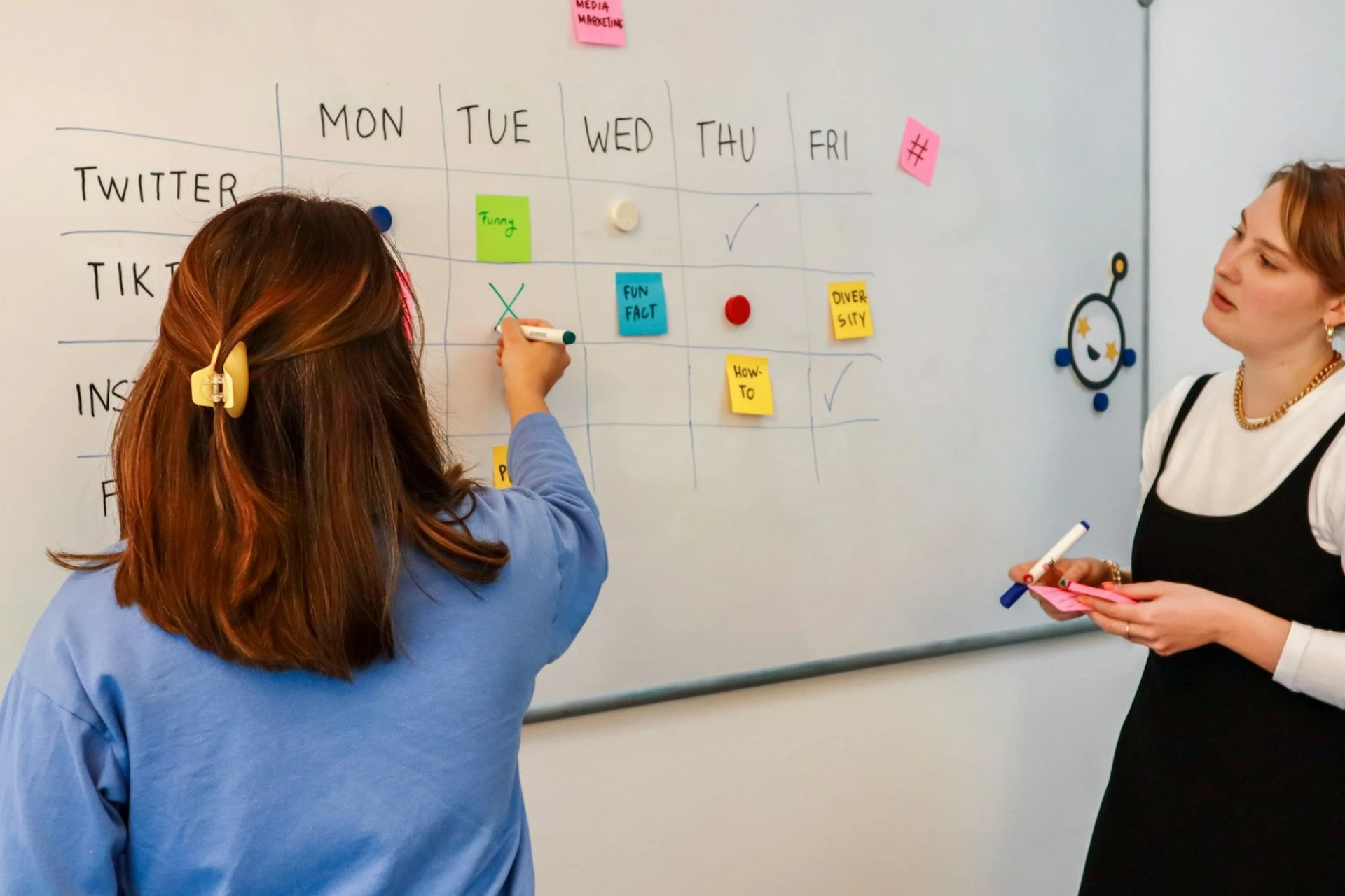 Two colleagues planning a content calendar for the week