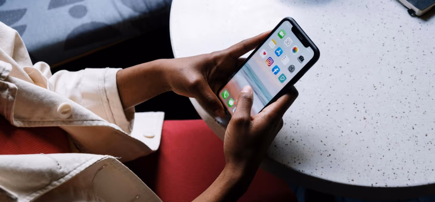 An individual seated at a table is gazing at their phone