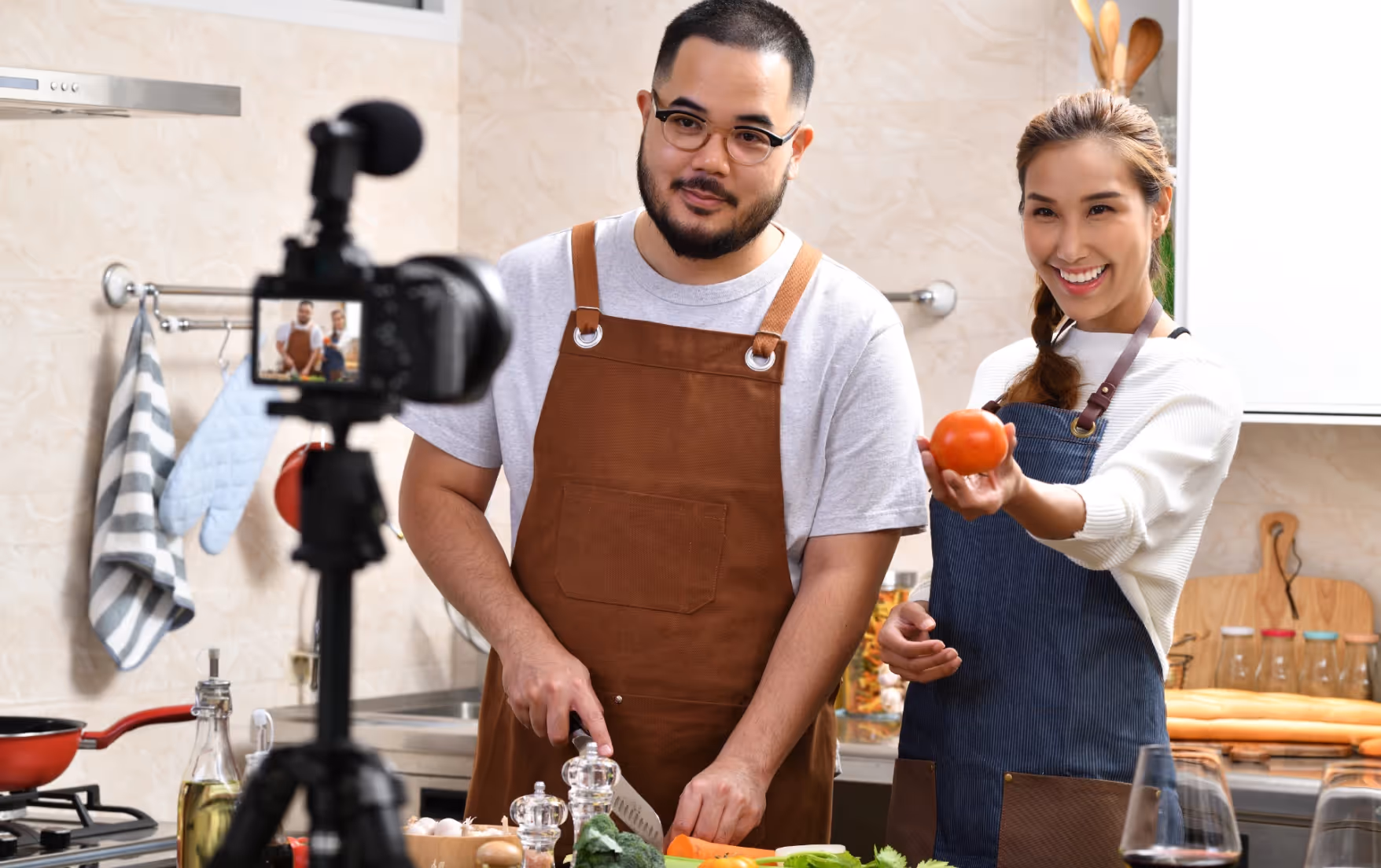 Two food creators cooking on camera