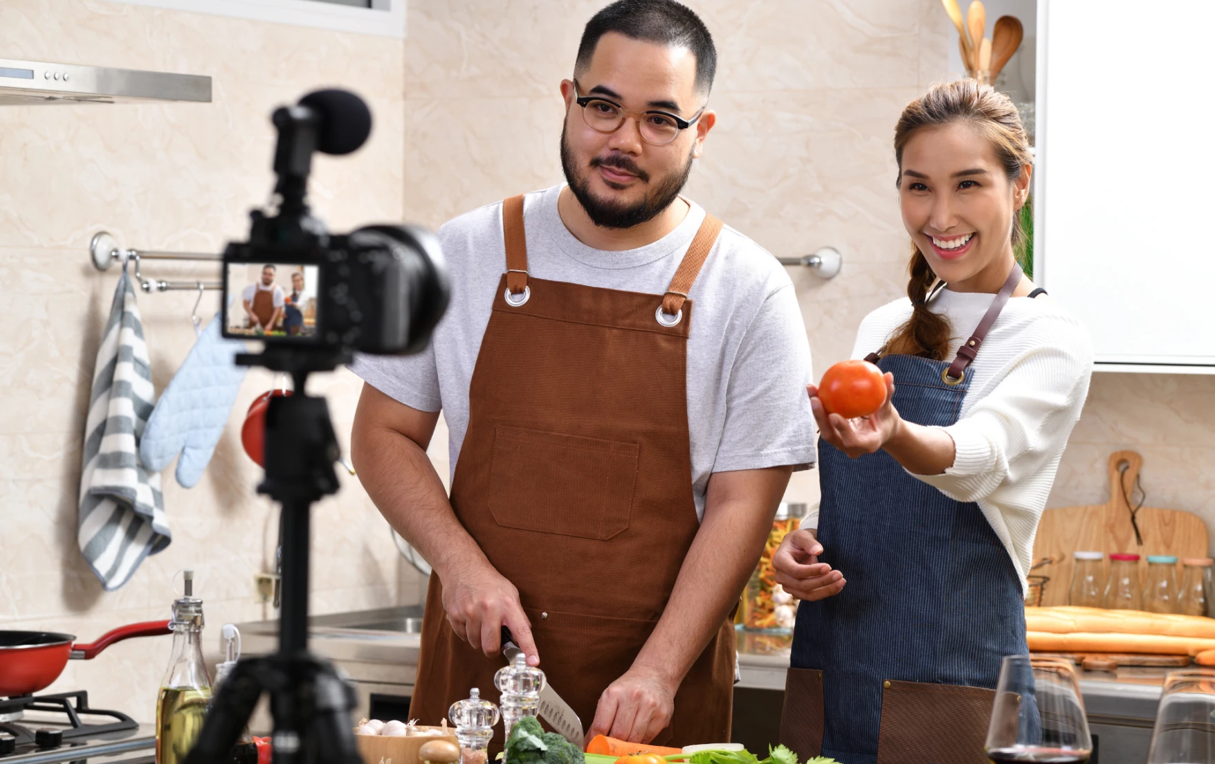 Two food creators cooking on camera