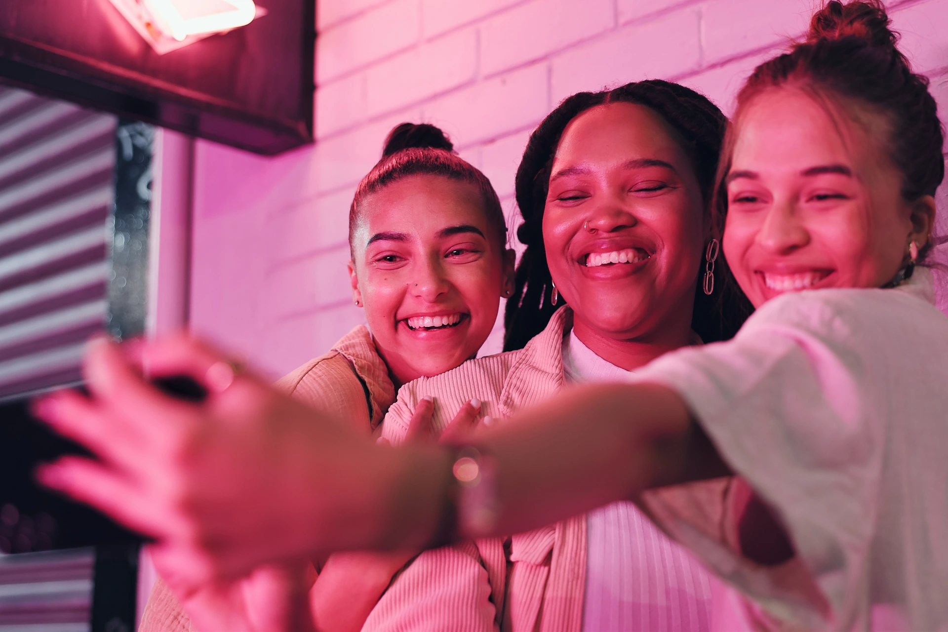 Influencers taking a selfie at a photo wall at an offline influencer marketing event