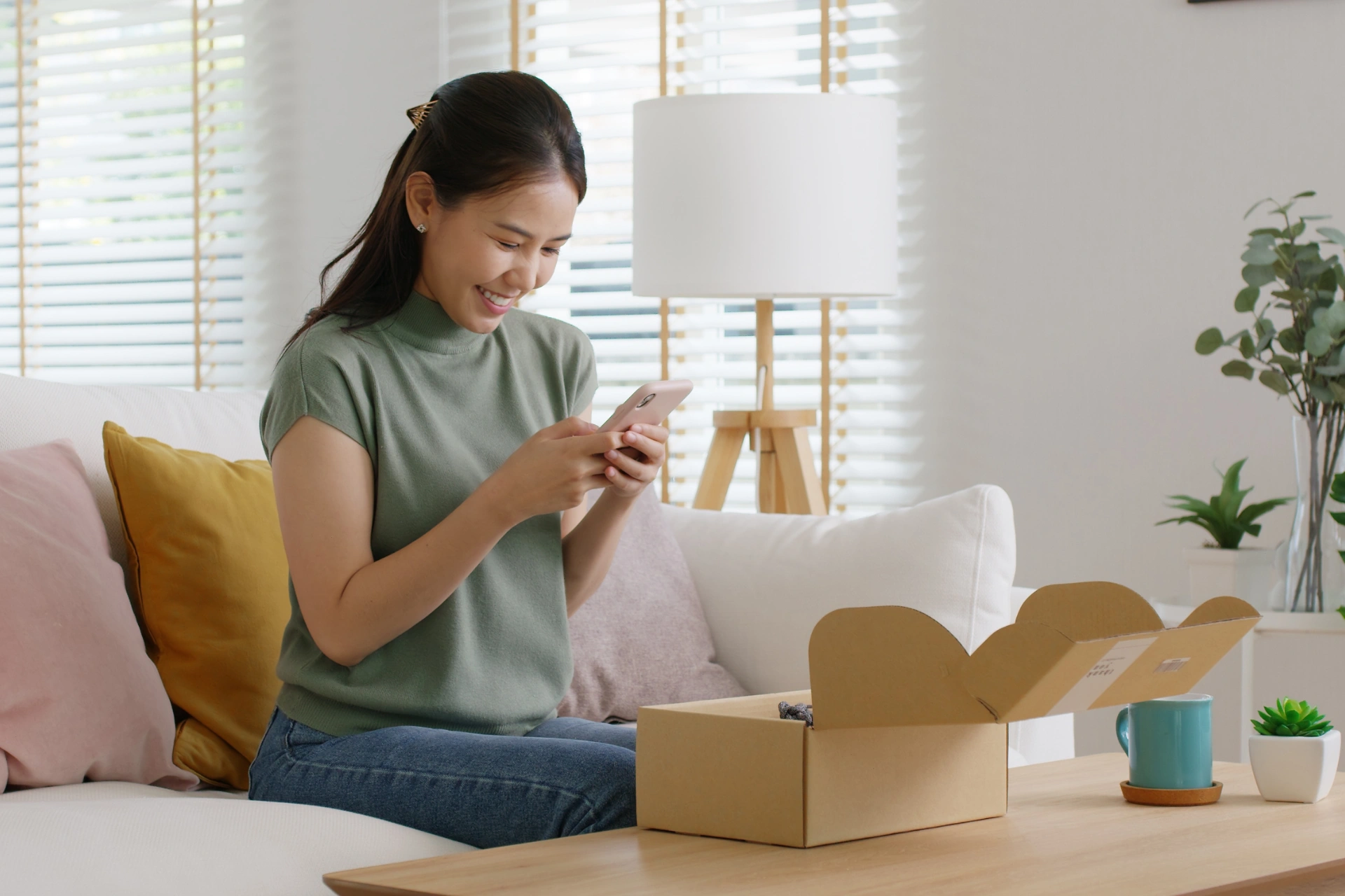 An influencer smiling and taking a photo of a PR package