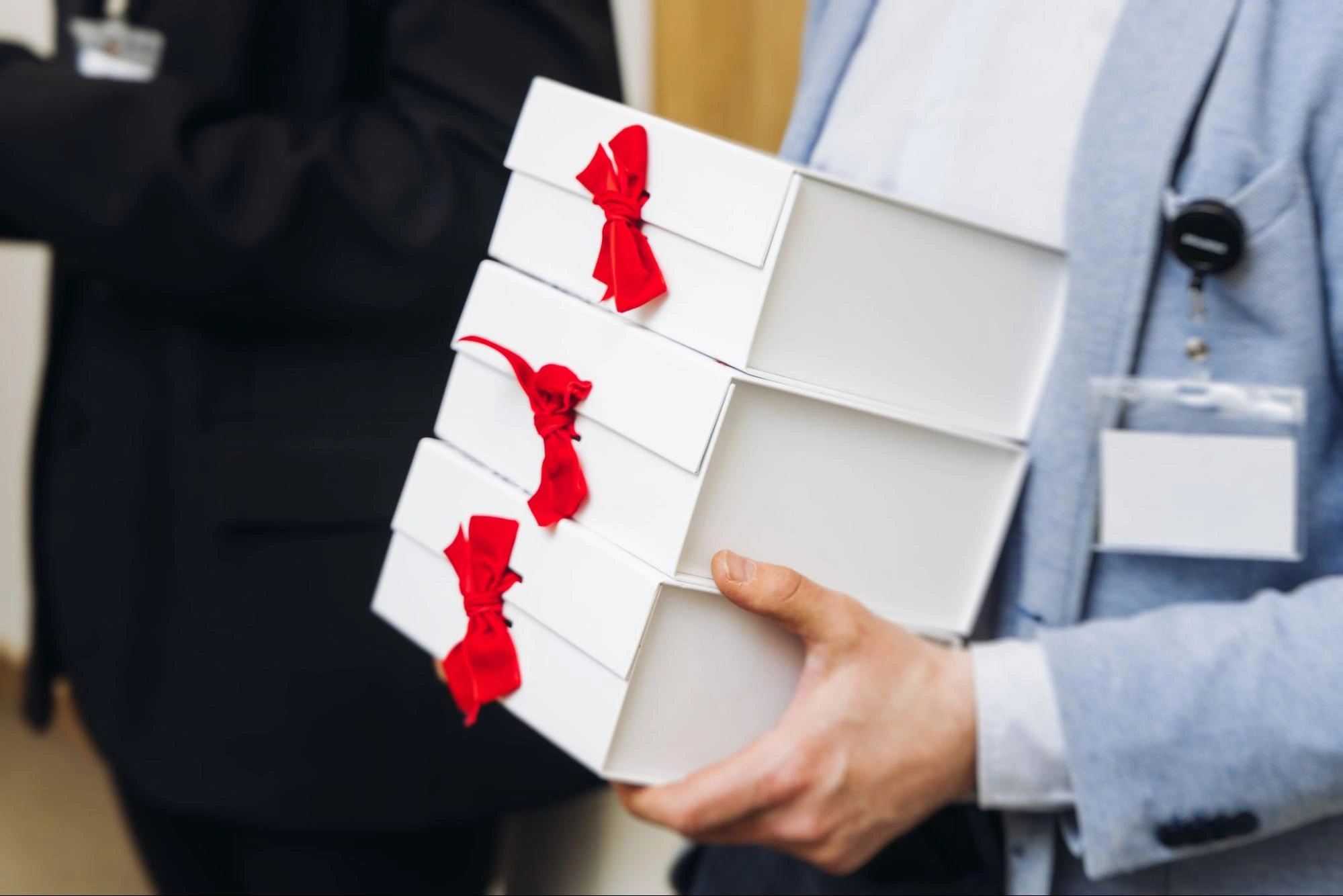 A person holding a stack of gift boxes