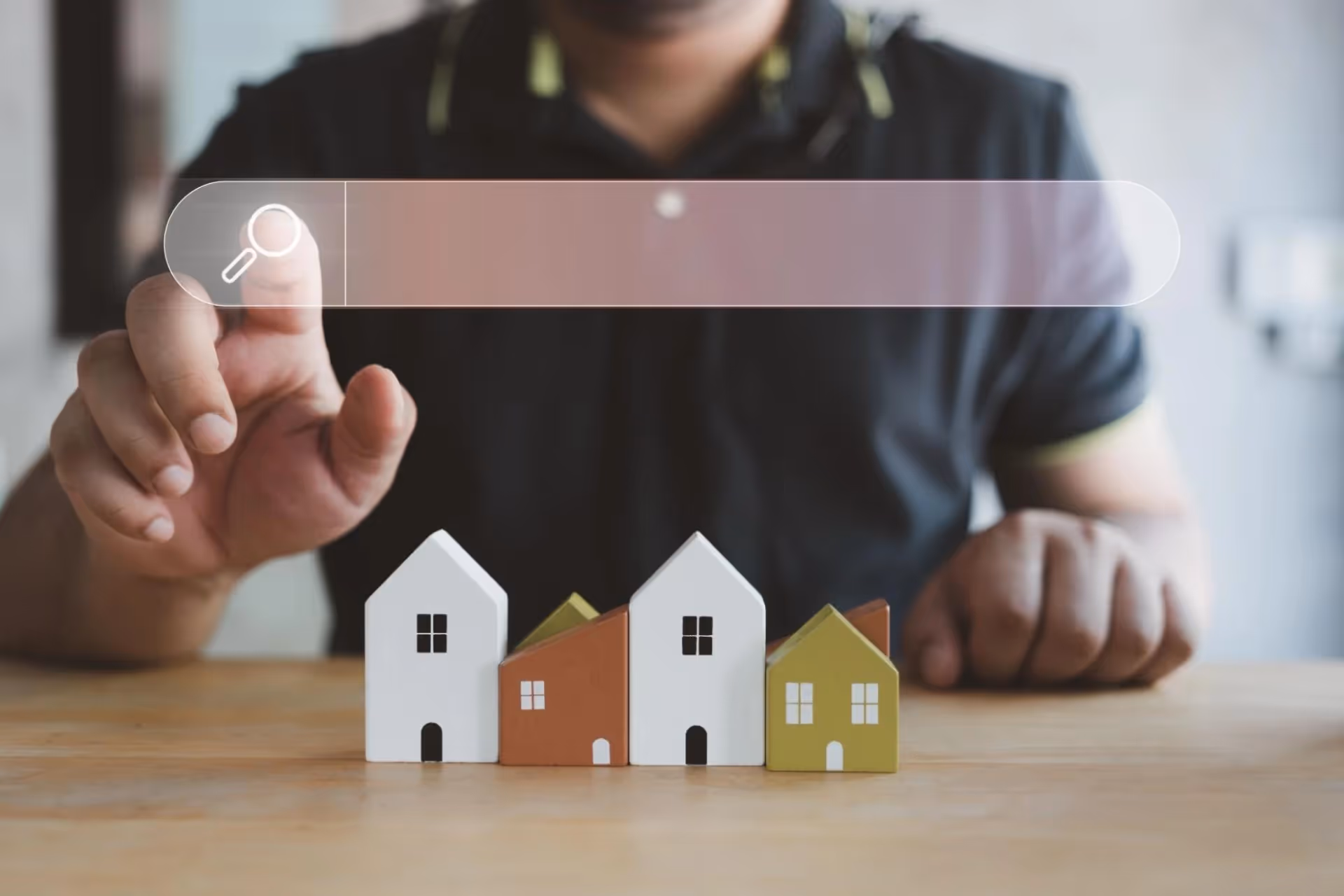 A man's hand is reaching for a magnifying glass icon while he sits at a table.