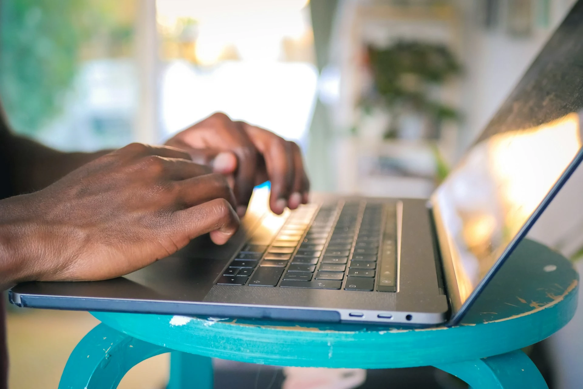 A closeup shot of a person typing into a laptop keyboard.