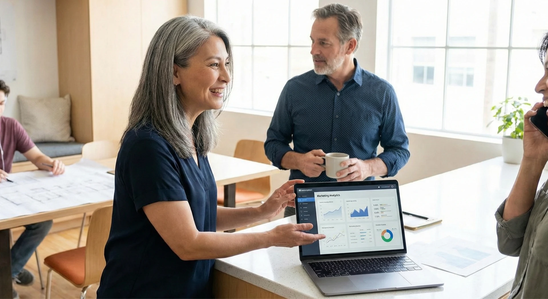 Gen X professionals reviewing digital data on a laptop in a modern home-office setting.