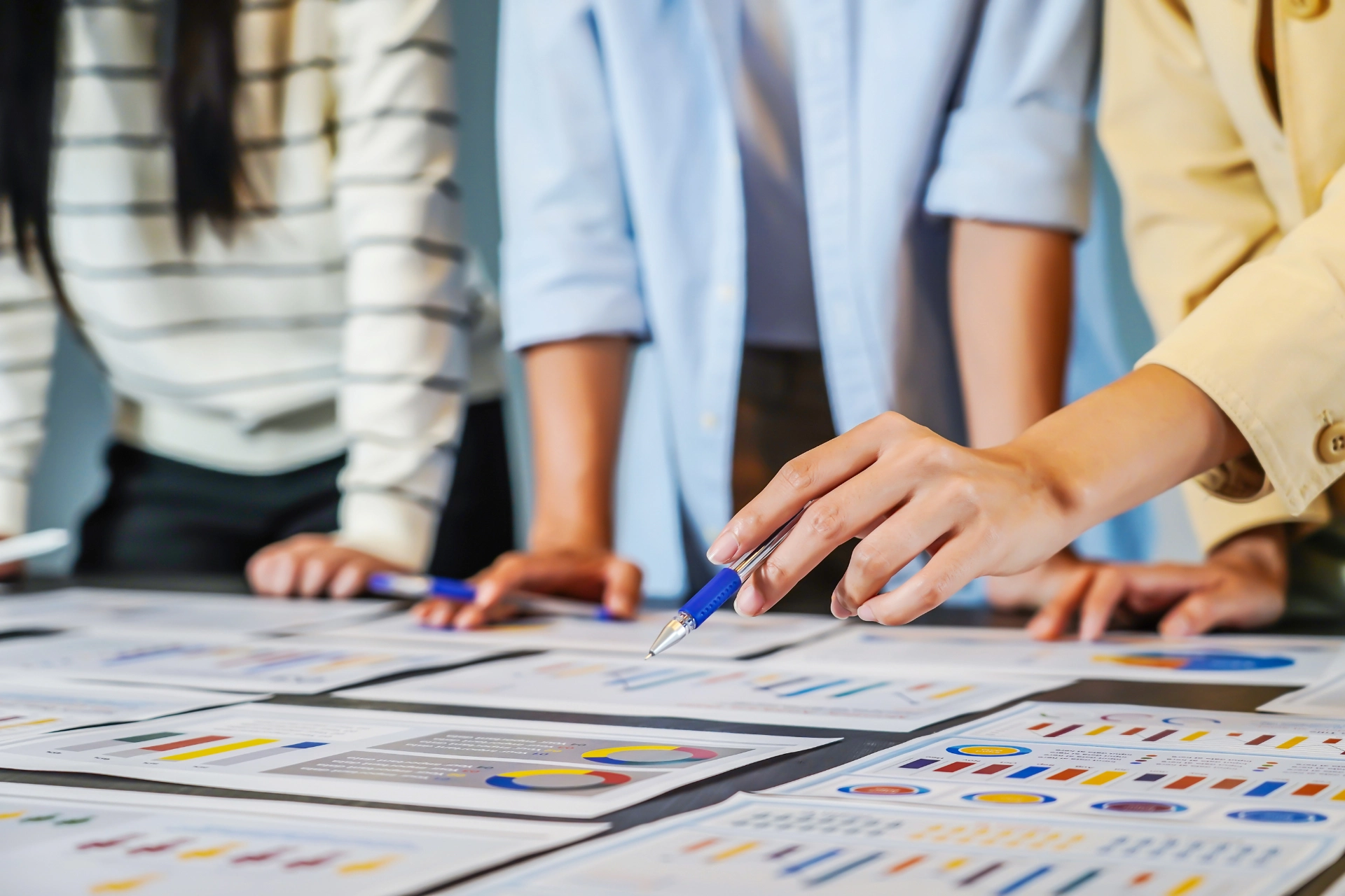 Team members reviewing printed analytics and SEO reports spread across a table during a collaborative meeting