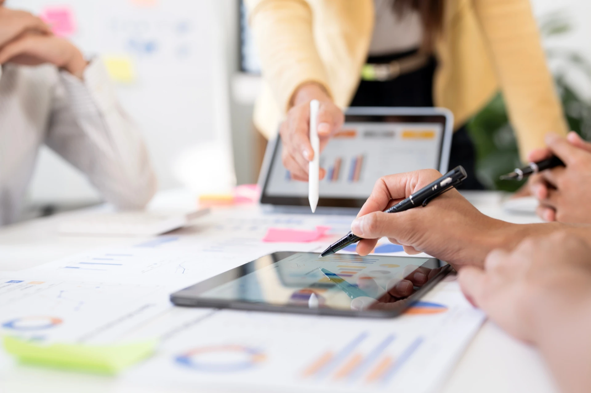 Close-up of business people reviewing financial data and charts in a team meeting