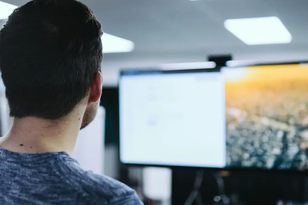 A man sits in front of computer monitor