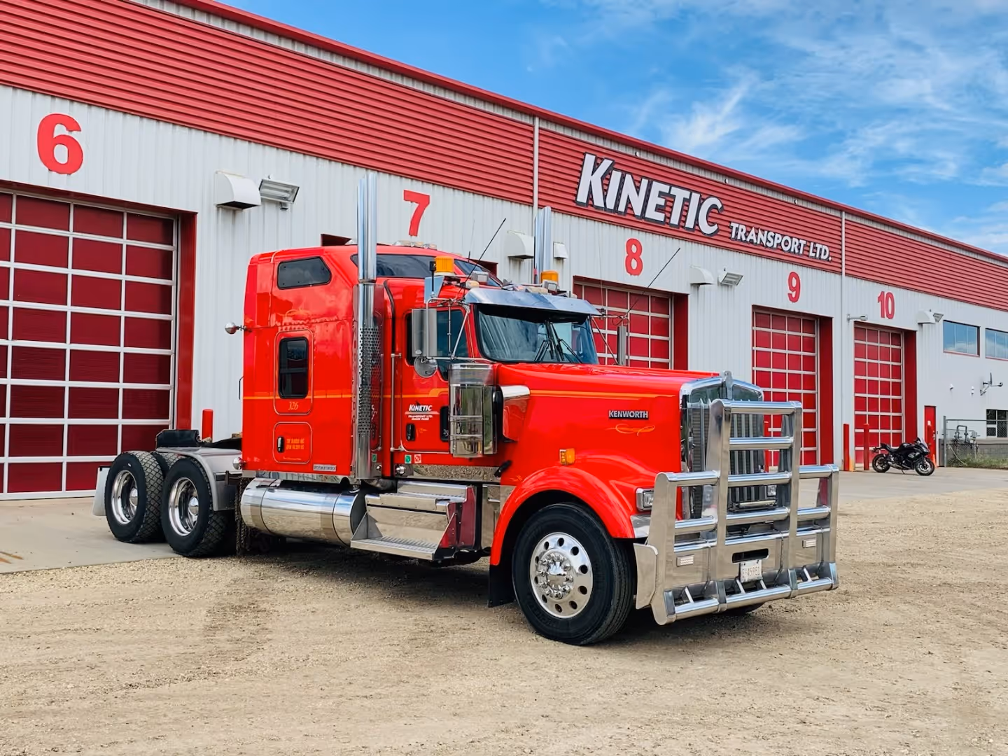 A red semi truck parked in front of a building