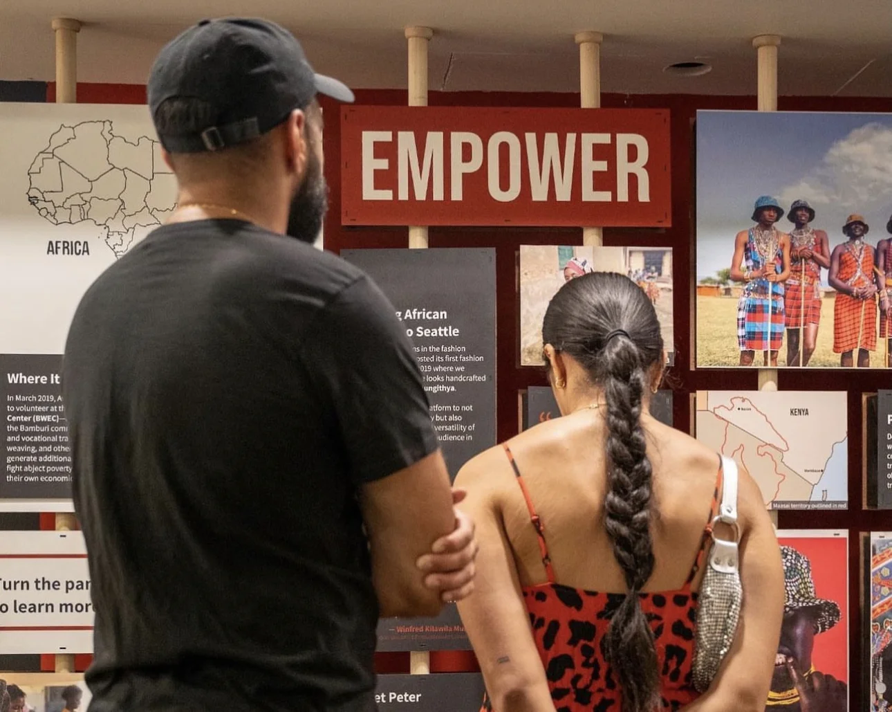 Close-up shot of a man and woman viewing our interactive turning panels installation with the word "EMPOWER" displayed above them