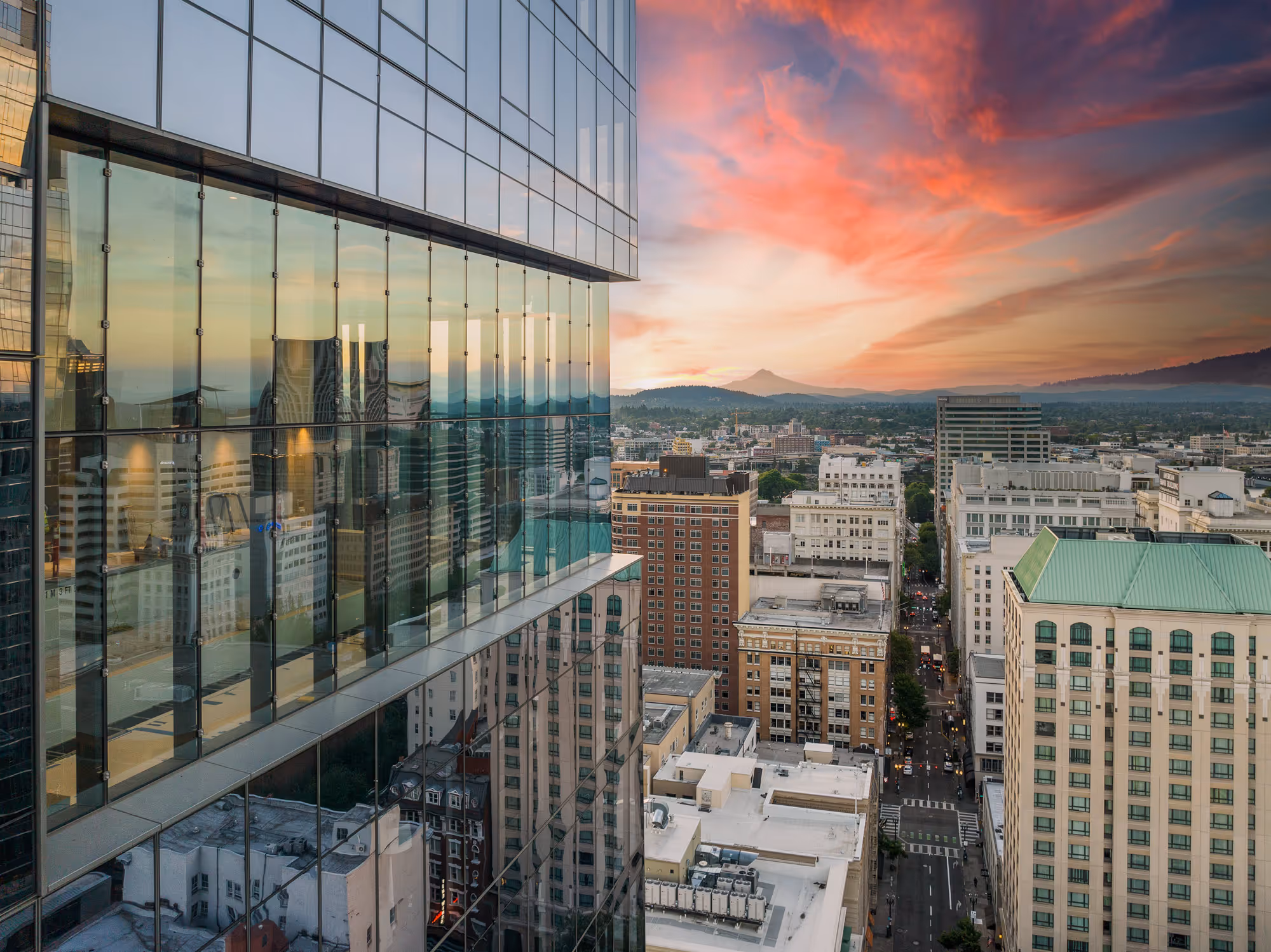 Sunrise over Mt Hood reflects in the glass facade of Block 216