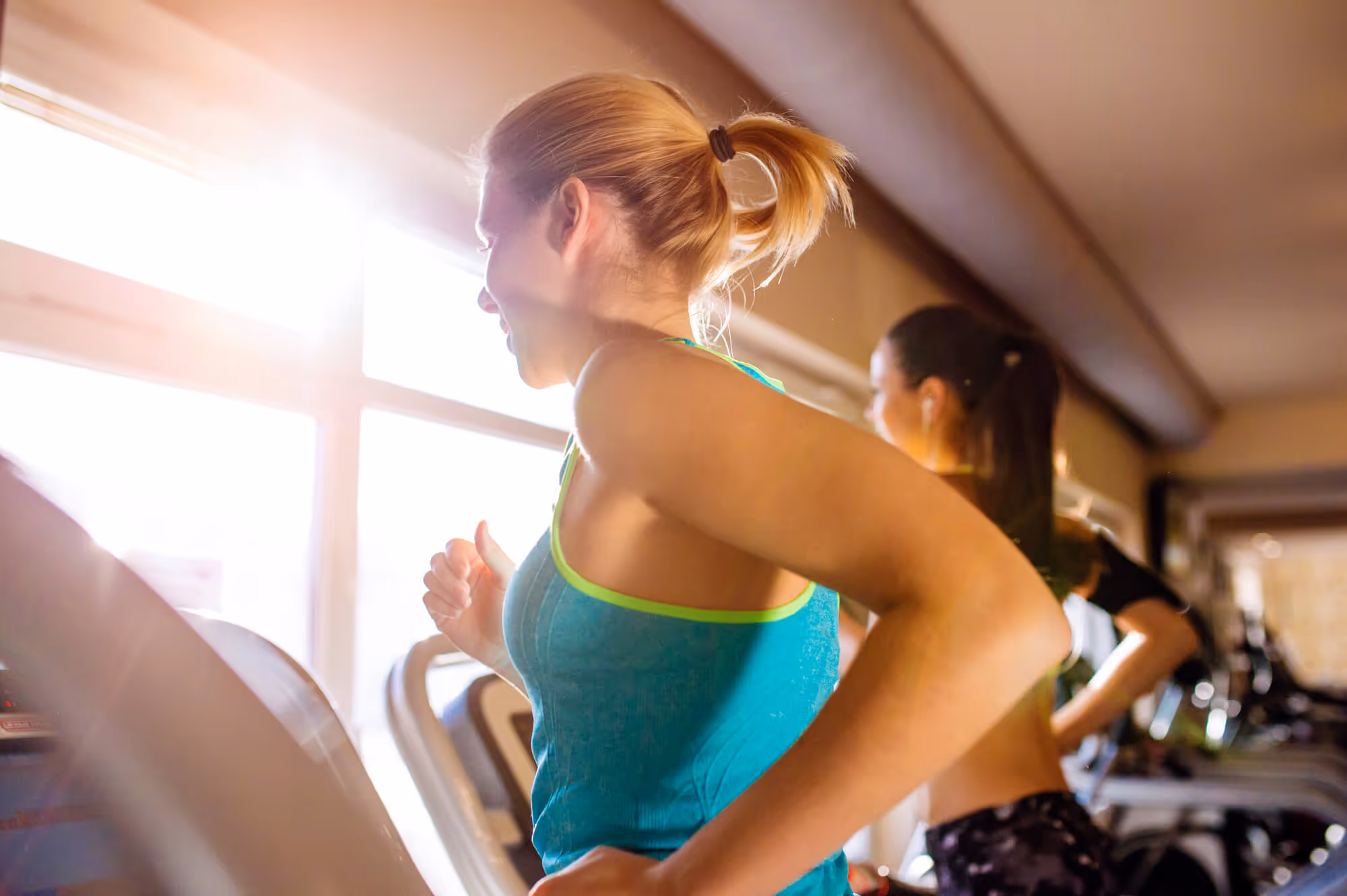 Two women running on treadmills