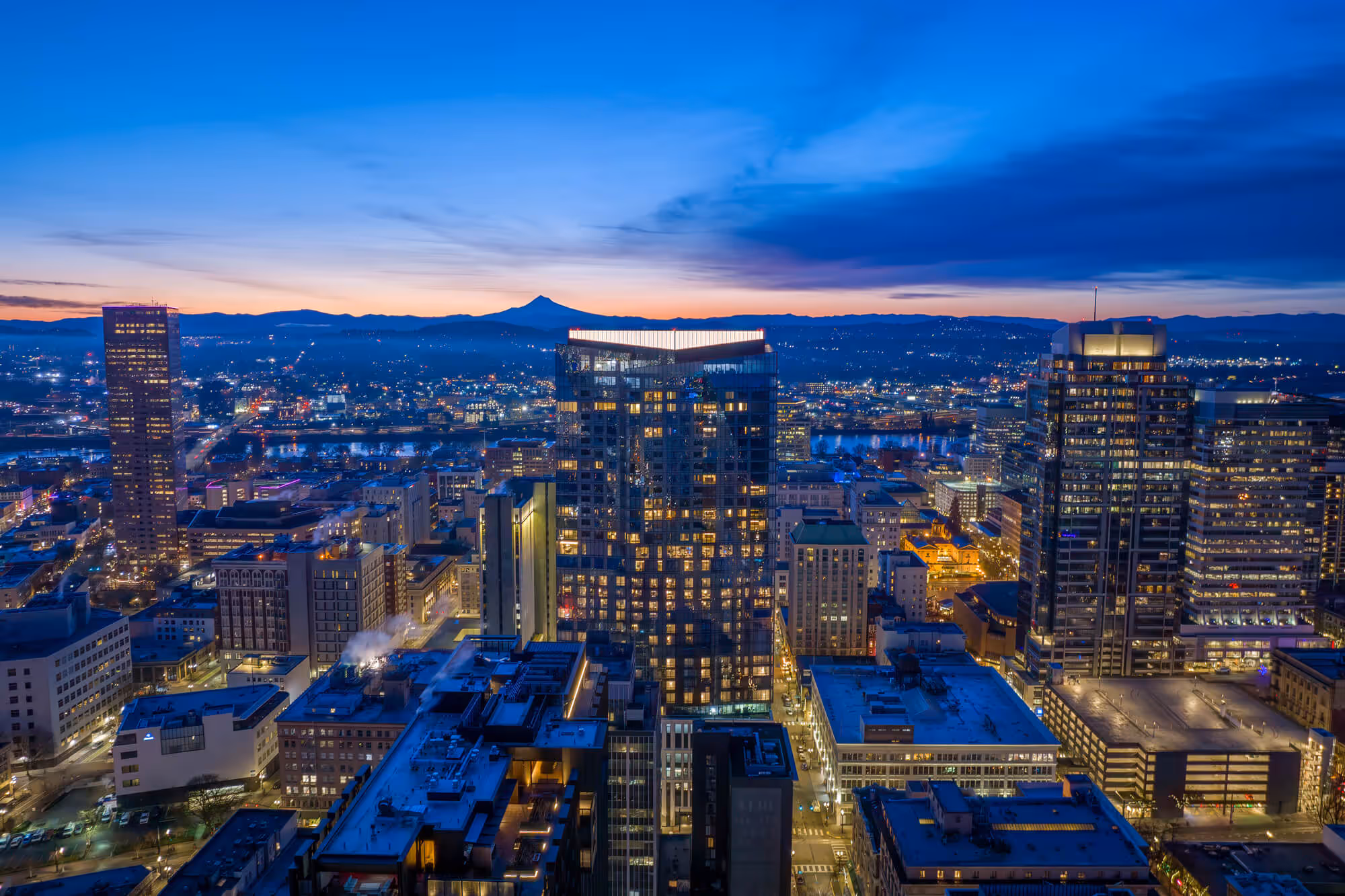 Sun rises behind Mt. Hood and the Block 216 building