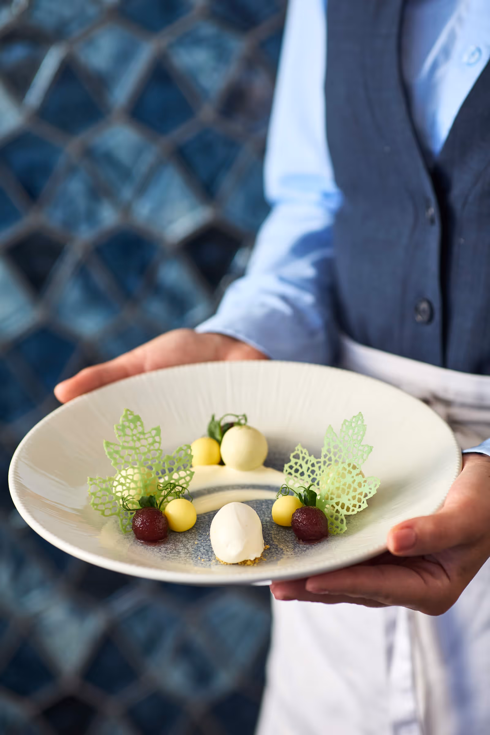 Server holding stunning dish at Bellpine, the Hotel Signature Restaurant on the 20th floor