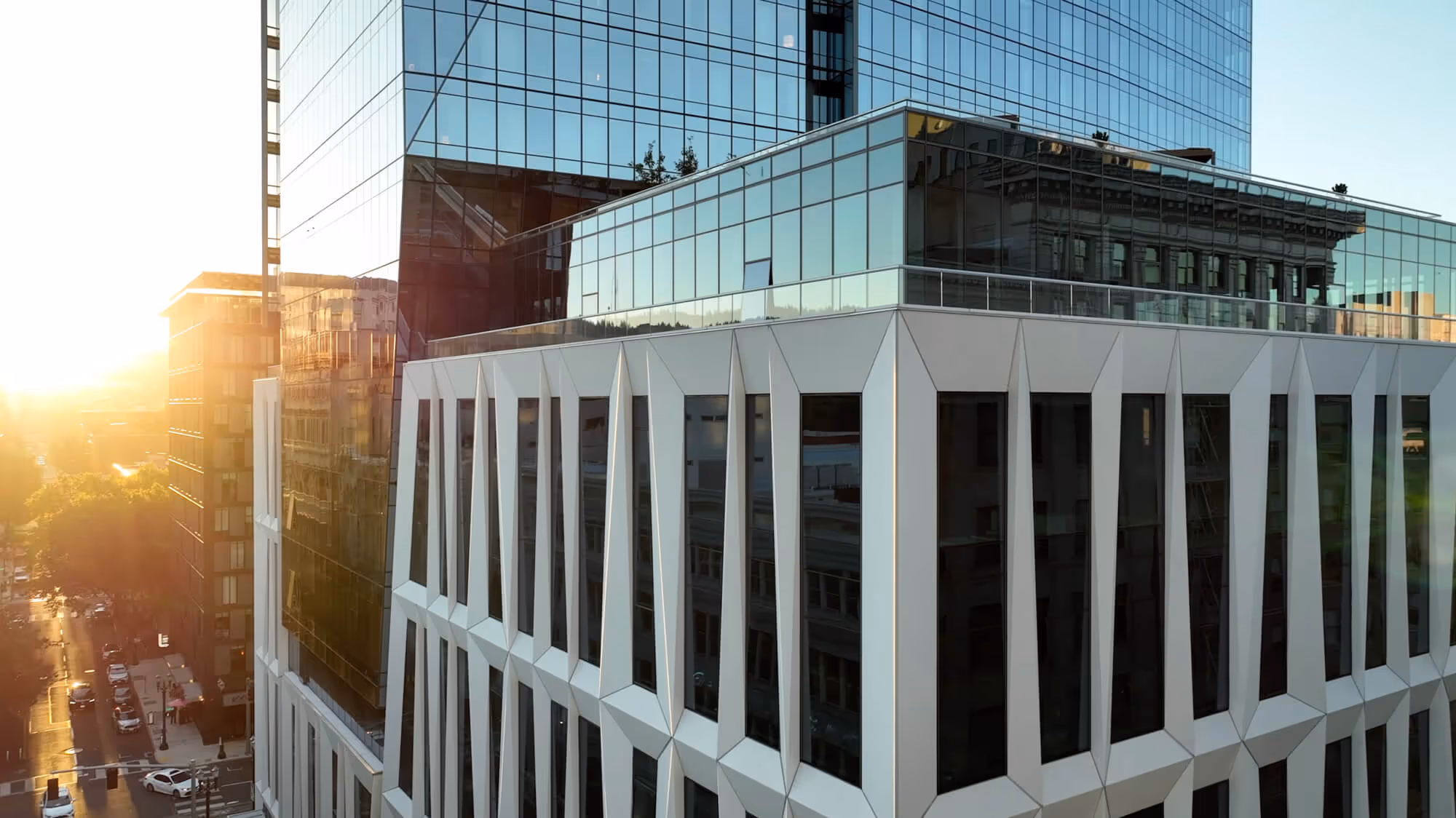 Block 216 building exterior with geometric white facade and reflective glass windows at sunset.