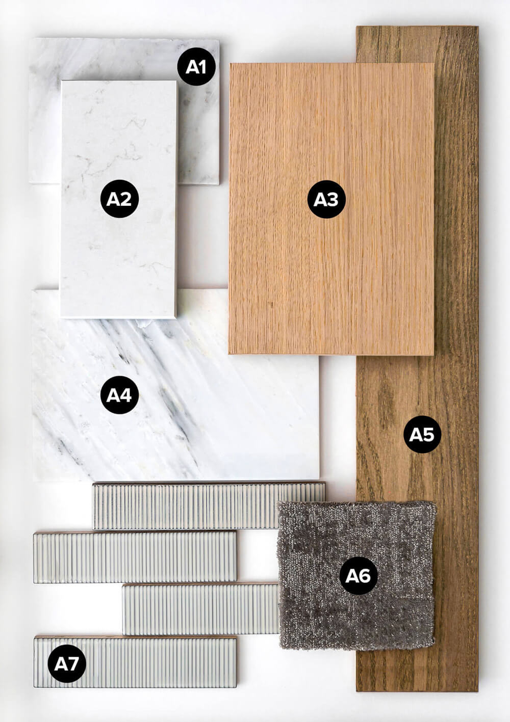 Collection of labeled interior finish samples including darkened hardwood flooring, light cabinet wood, white quartzite and marble tiles, a dark grey carpet swatch, and llight grey rectangular tiles on a white background.