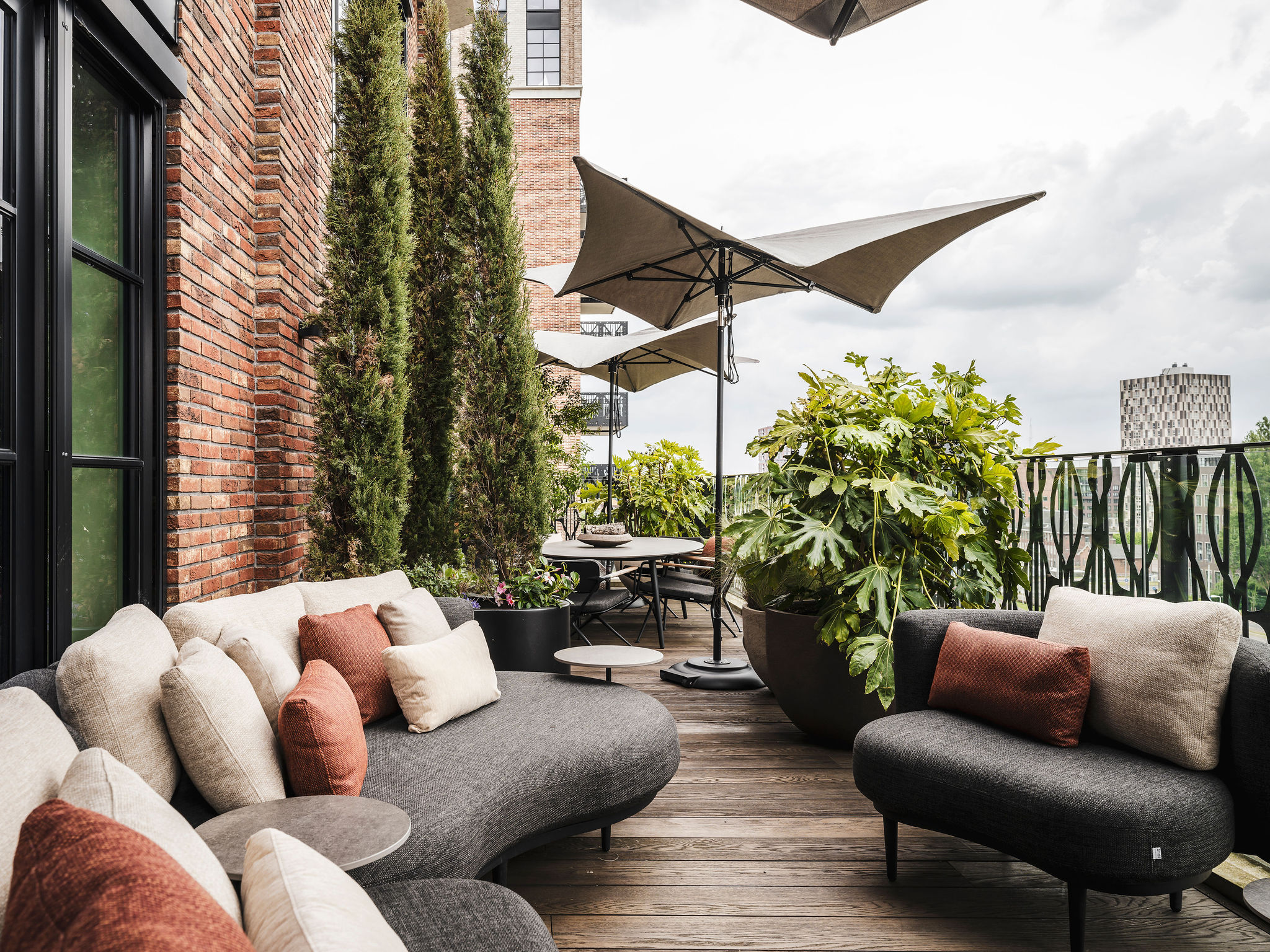 A patio with a couch, chairs and an umbrella