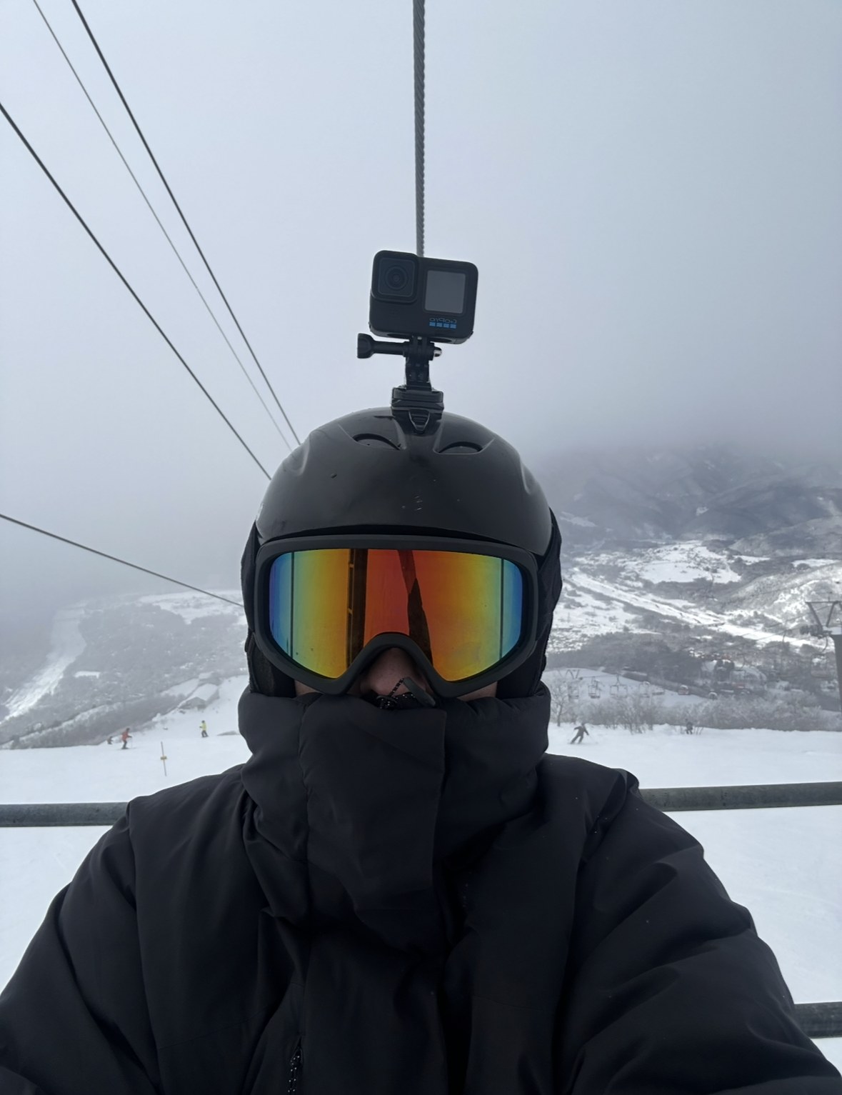 Ethan on a chairlift in snowboarding gear in Japan