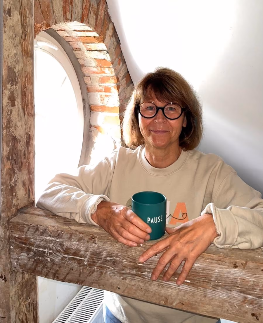 Sabine Steinbeck mit einer Tasse in der Hand, auf der "Pause" steht