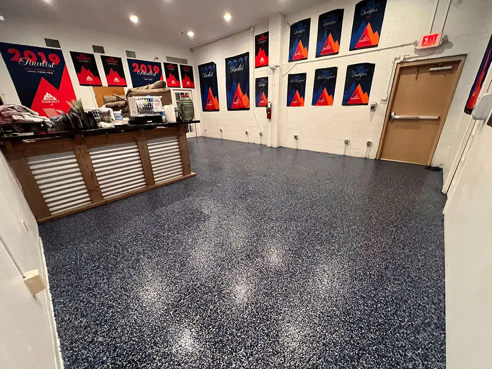 Room with black epoxy floor and red posters on the wall.