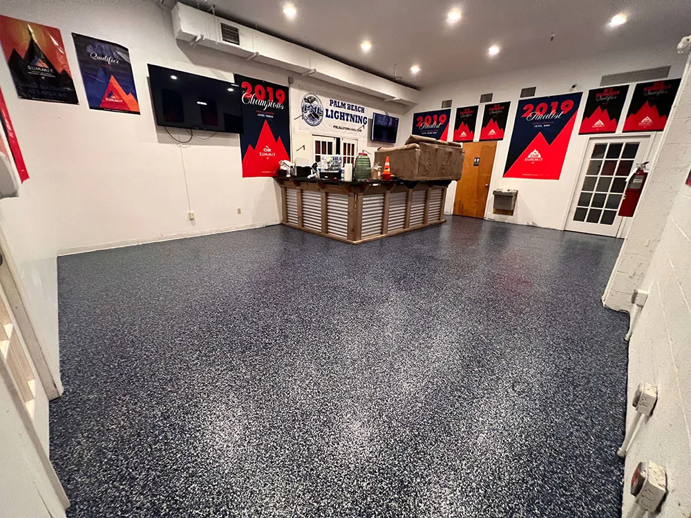 Room with black epoxy floor and red posters on the wall.