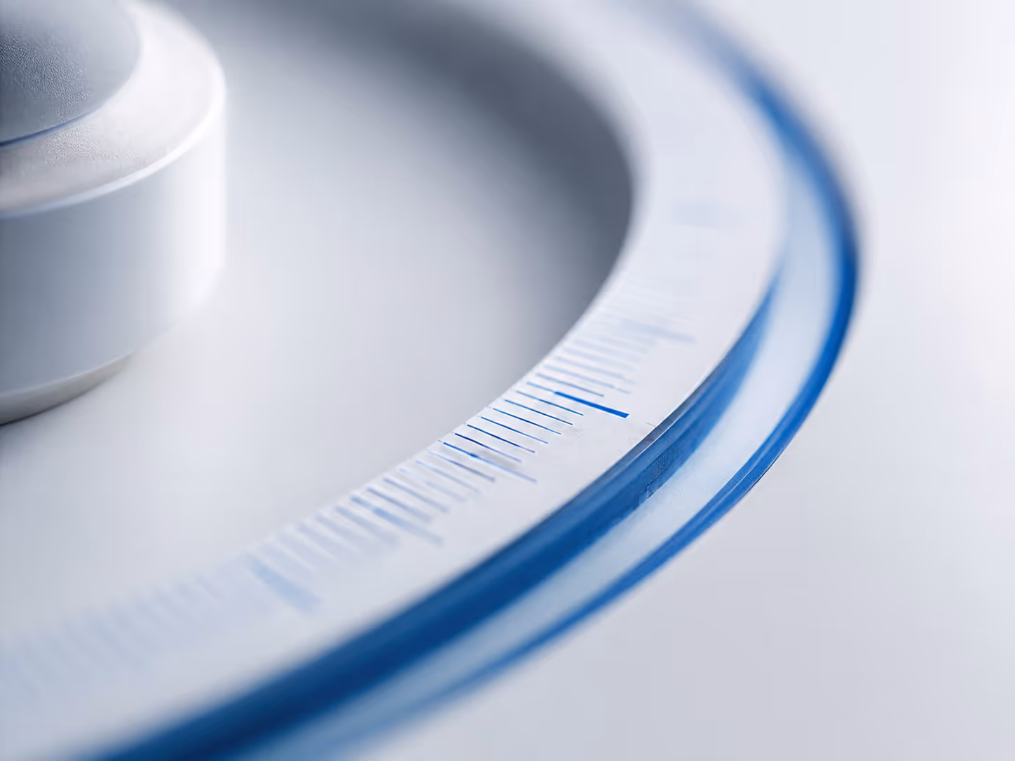 Close-up of a white dial with blue measurement markings and a rotating knob.