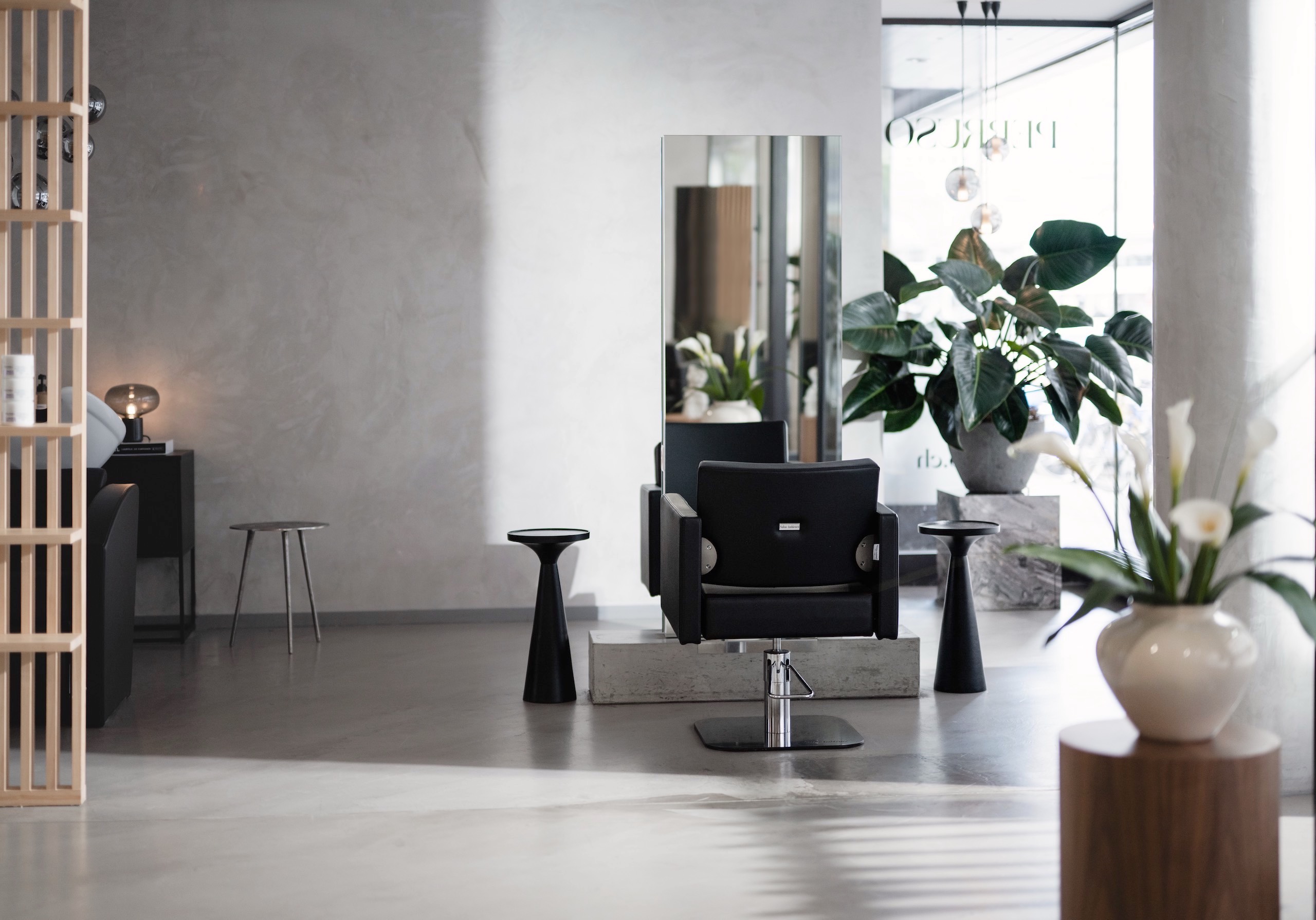 Hair salon with concrete floor and stucco veneziano wall.