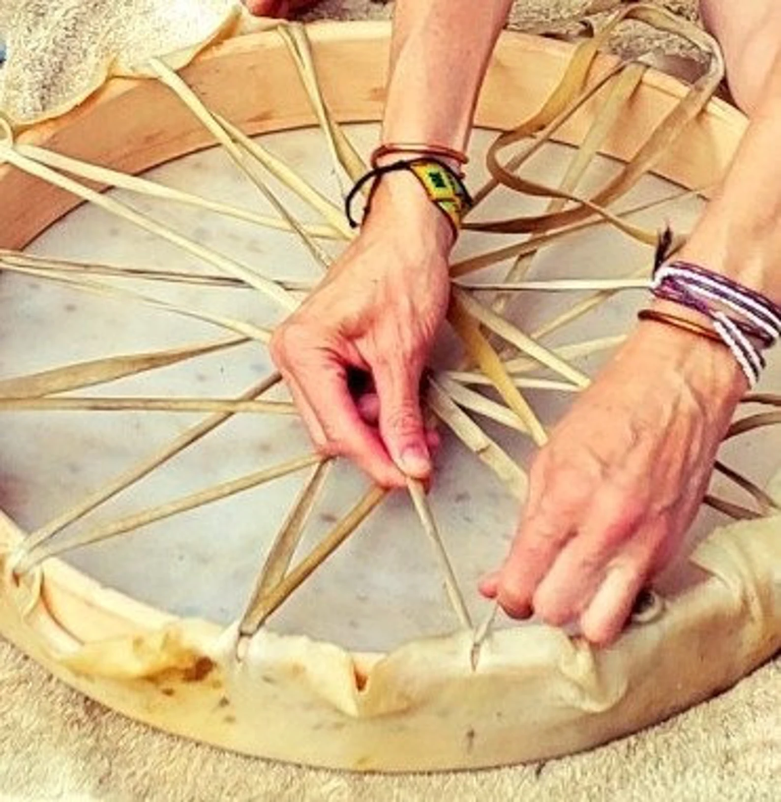 Hands lacing a drum