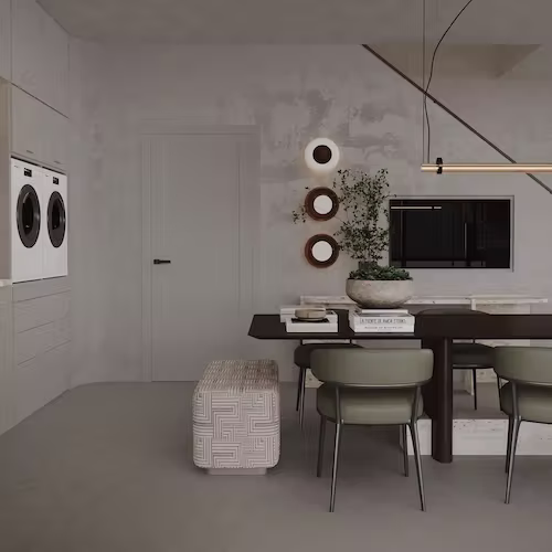 Minimalist modern dining area with dark rectangular table, four olive-green chairs, a patterned ottoman, wall-mounted washer and dryer, and decorative round mirrors and plant on wall.