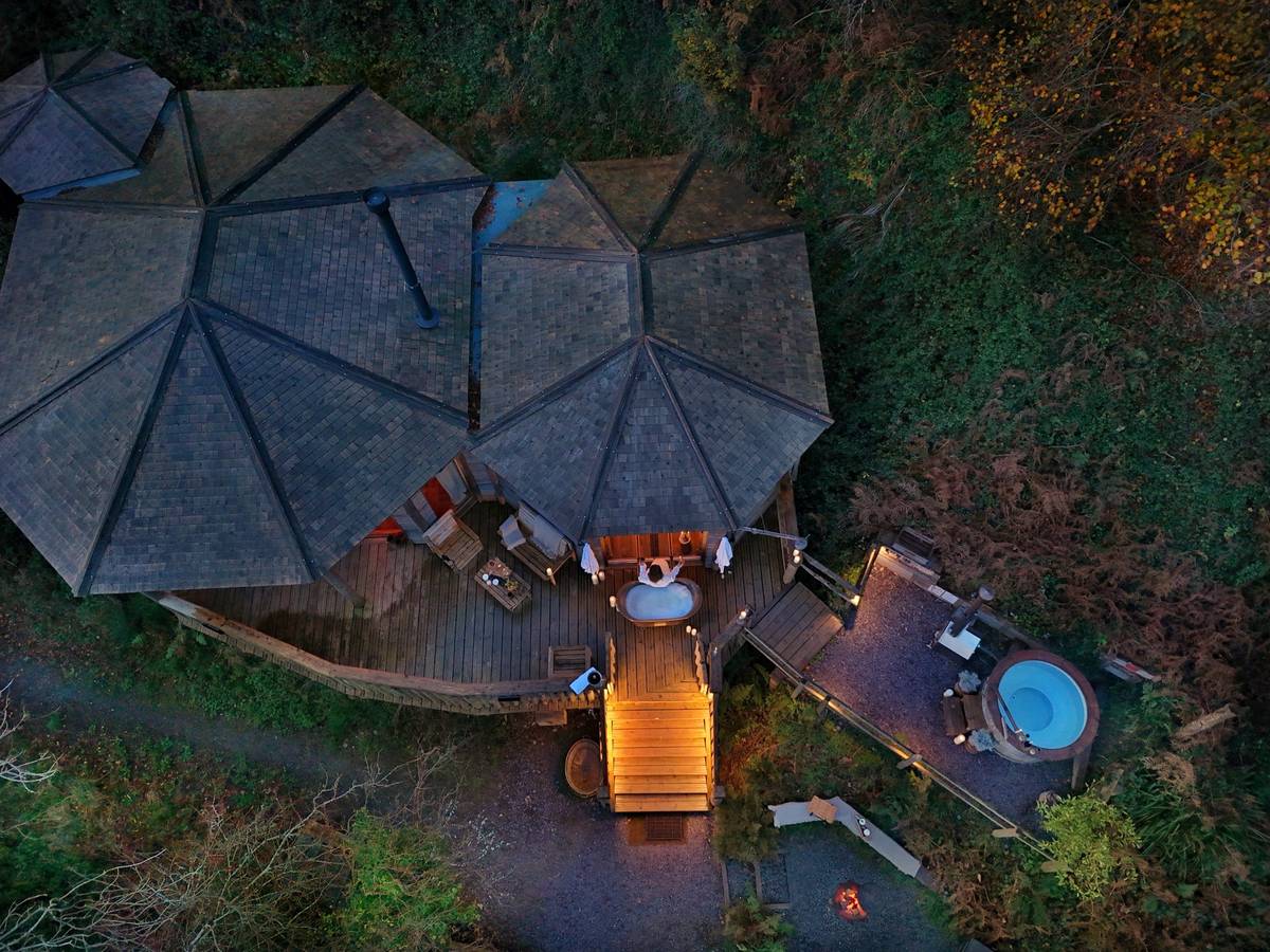 Aerial view of woodland spa lodge with outdoor hot tubs