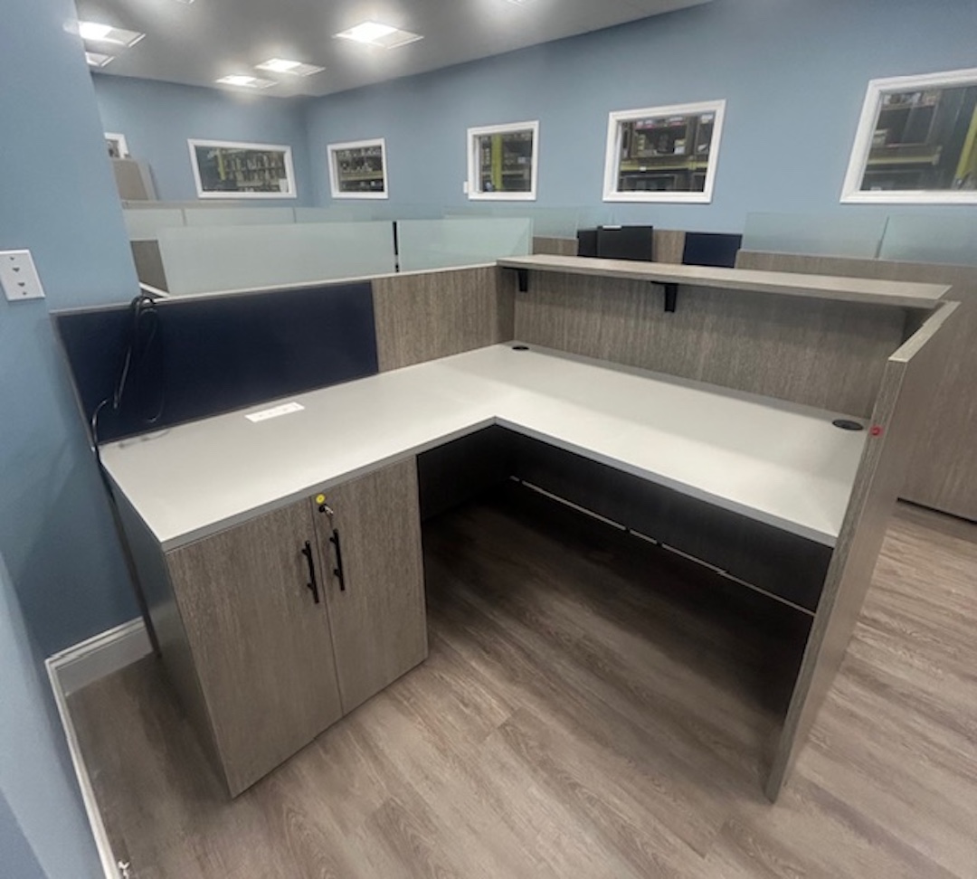 Corner office workstation with raised privacy divider, overhead shelf, and ample counter space for computer equipment.