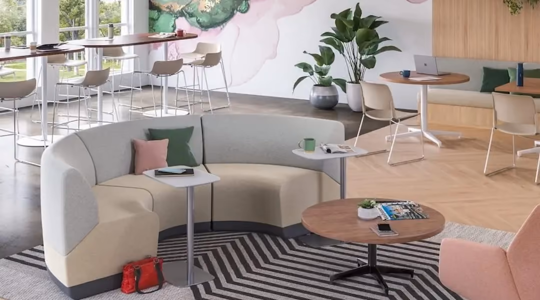 A modern office breakroom with comfortable lounge seating and small side tables designed for employee relaxation and informal gatherings