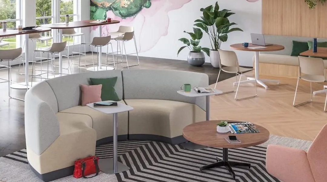 A modern office breakroom with comfortable lounge seating and small side tables designed for employee relaxation and informal gatherings