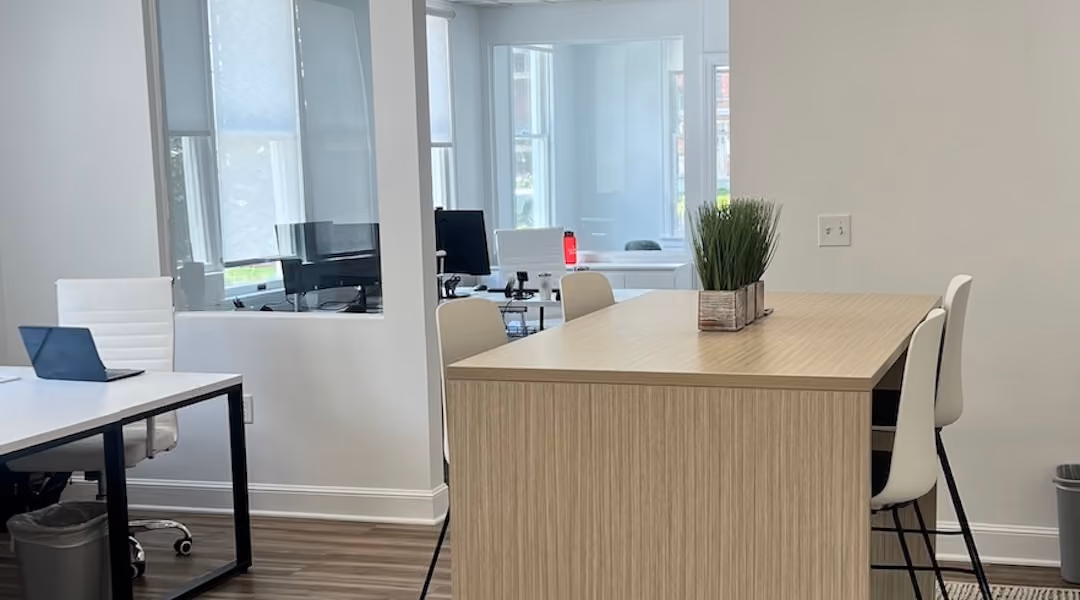 High-top collaborative meeting table and stools in a bright modern office — hybrid workspace furniture solutions from Office Gallery for Boston-area businesses