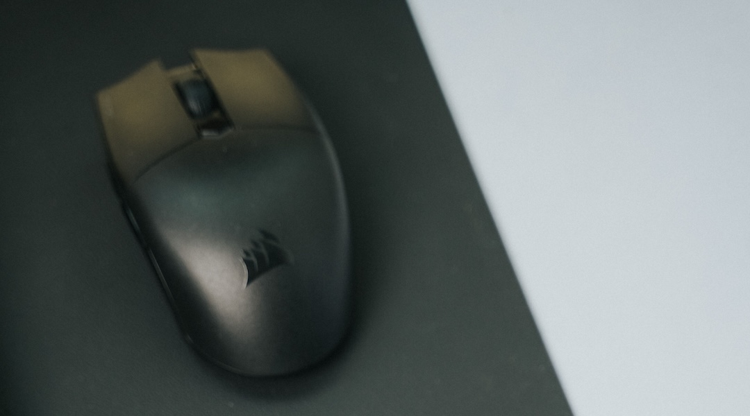 Close-up of a modern office desk with a mouse and pad, highlighting minimalistic design.