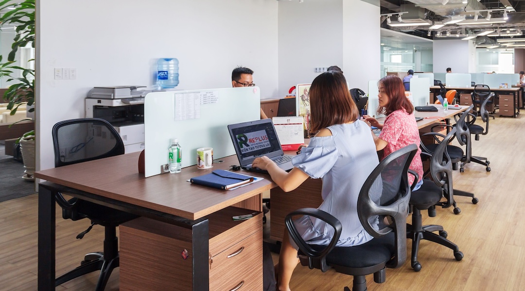 Spacious modern office in Vietnam with employees collaborating at desks.