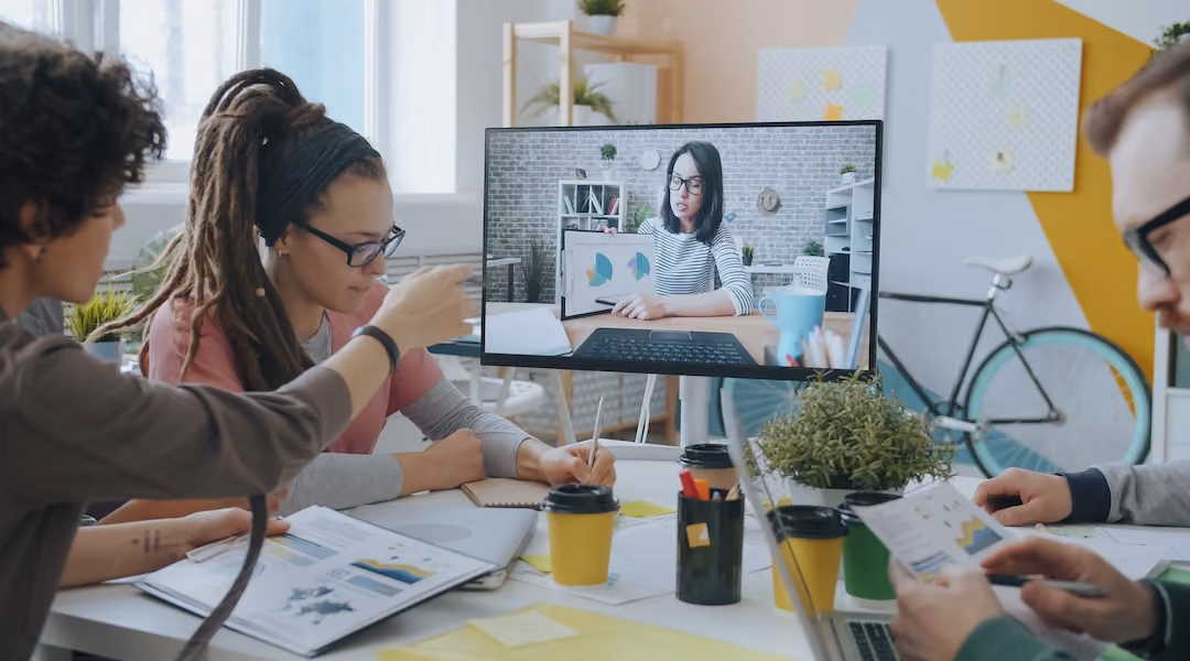 Young professionals collaborate during a video call in a creative and modern office setting.