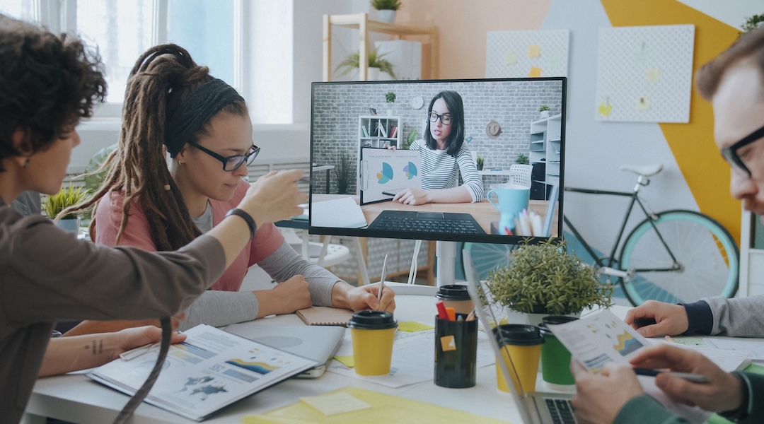 Young professionals collaborate during a video call in a creative and modern office setting.