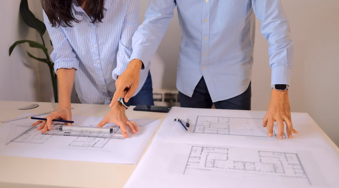 Architects and engineers collaborating on detailed blueprints, reviewing structural plans and working together on innovative architectural designs for a new building project  Standard license (1 Plan credit)