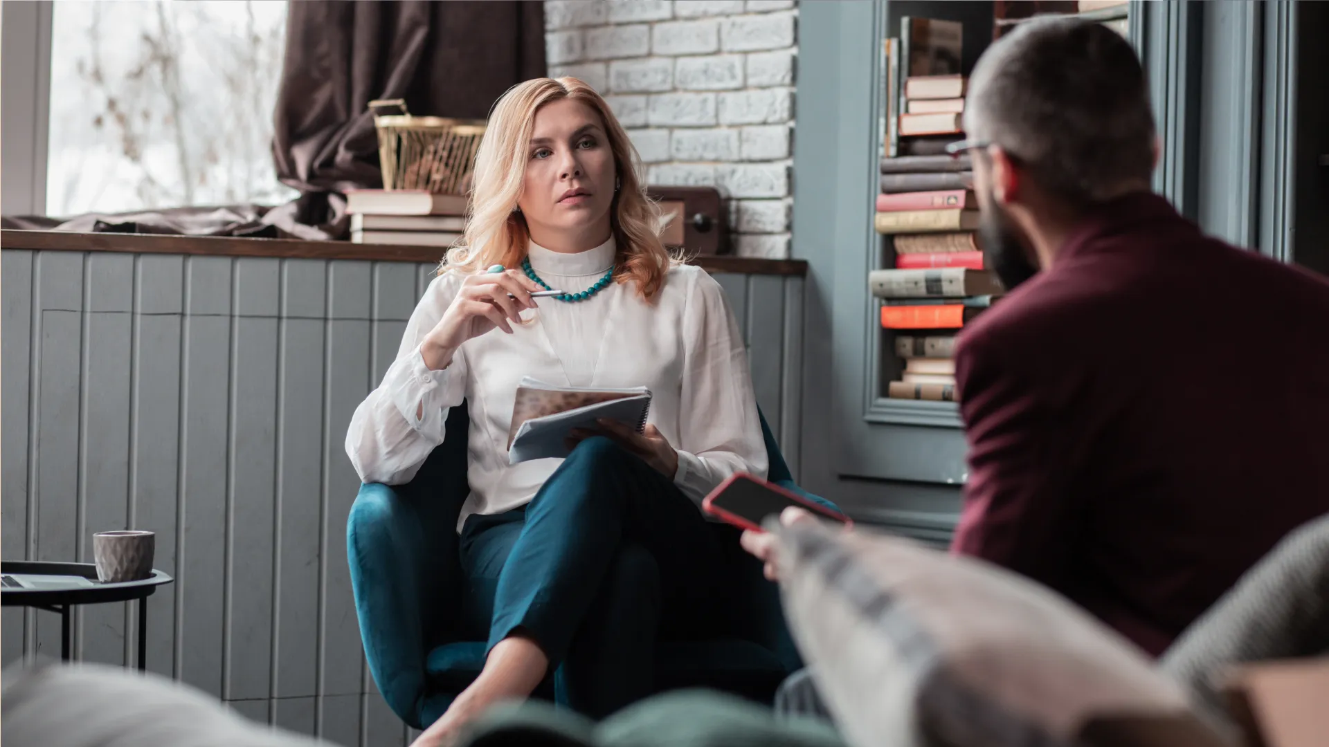 Therapist attentively listening to a patient during a counseling session in a cozy office setting.