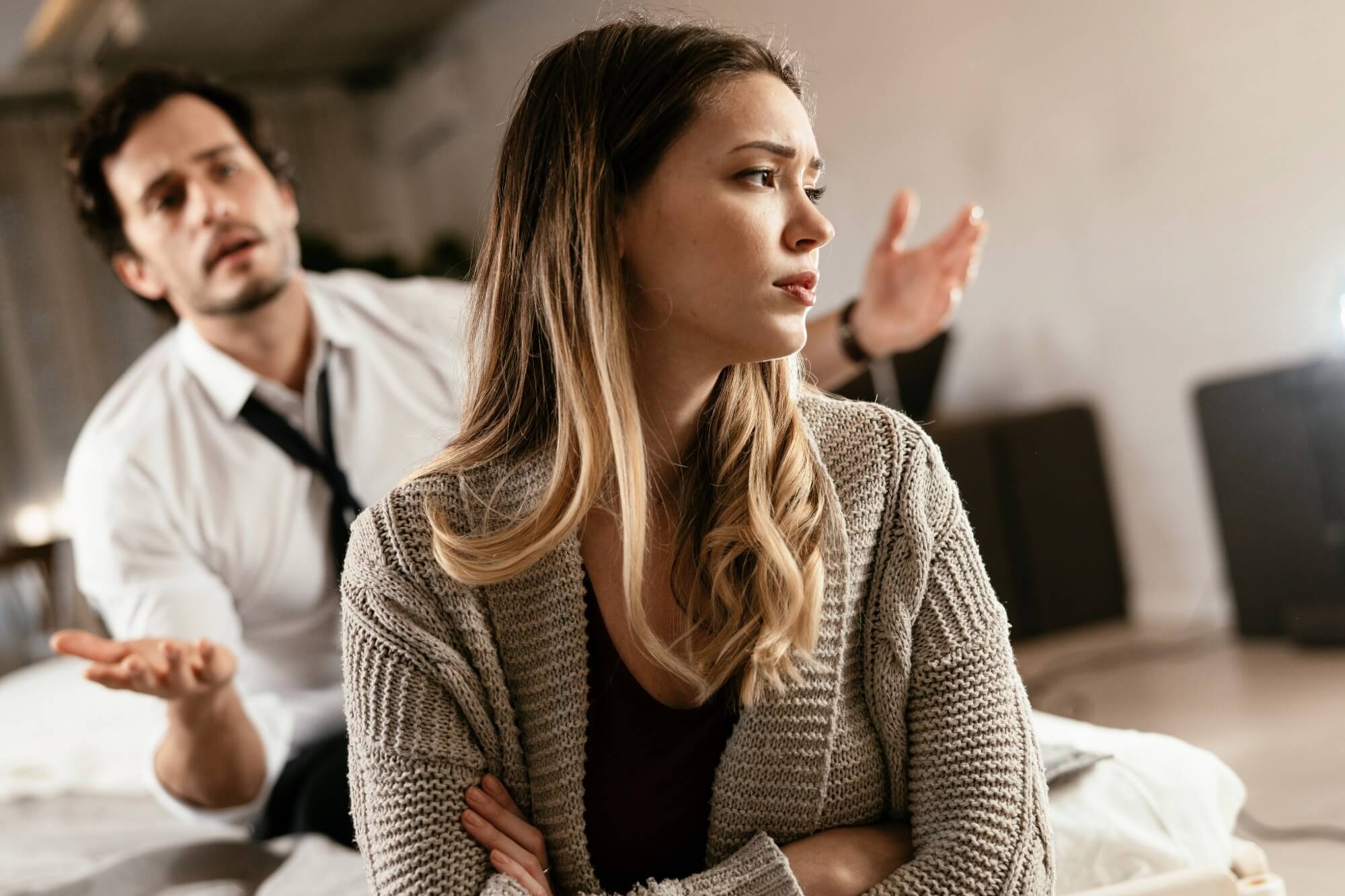 Woman looking away, man gesturing behind her.
