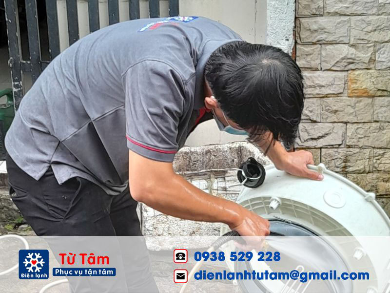 Kĩ thuật viên đang sửa chữa máy giặt rung lắc trong quá trình giặt