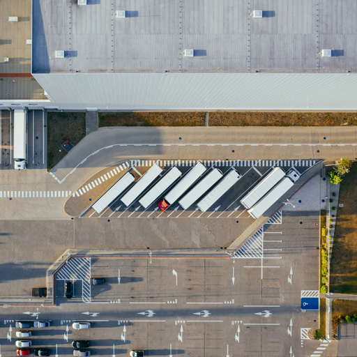 Luftaufnahme eines Logistikzentrums mit Lkw an den Verladerampen