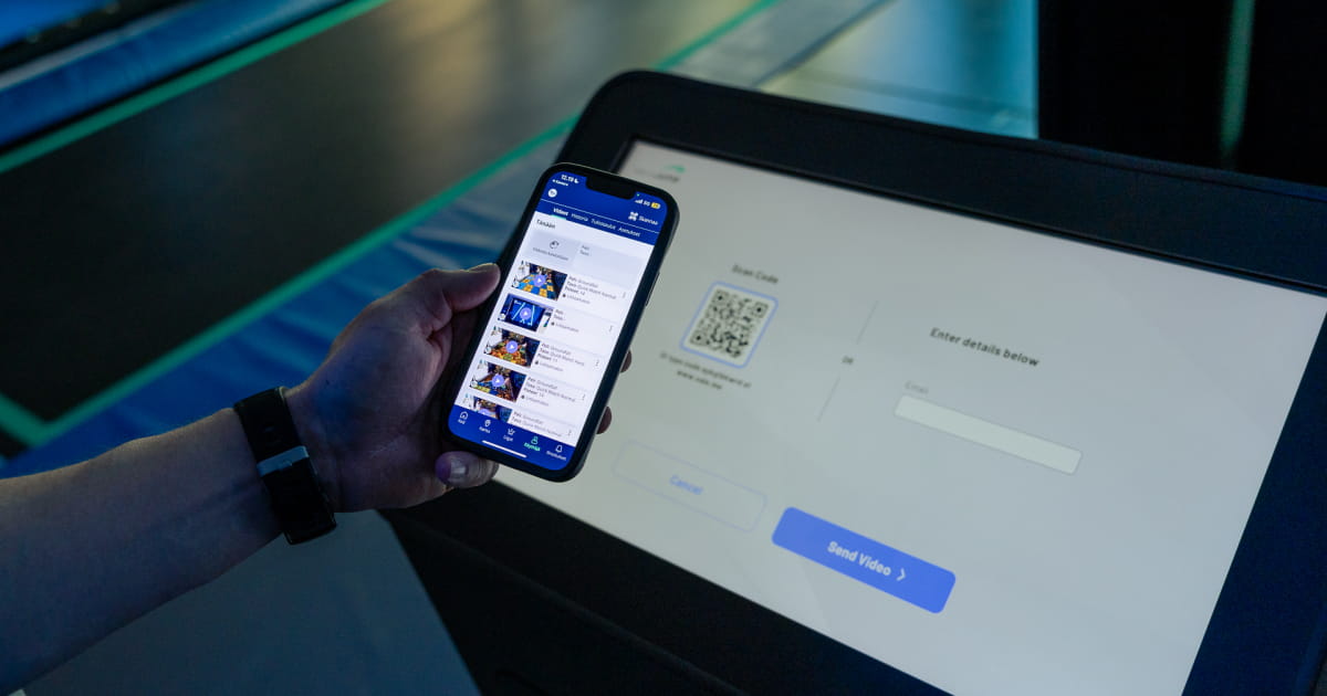 Person holding smartphone with ValoApp next to ValoJump touchscreen.