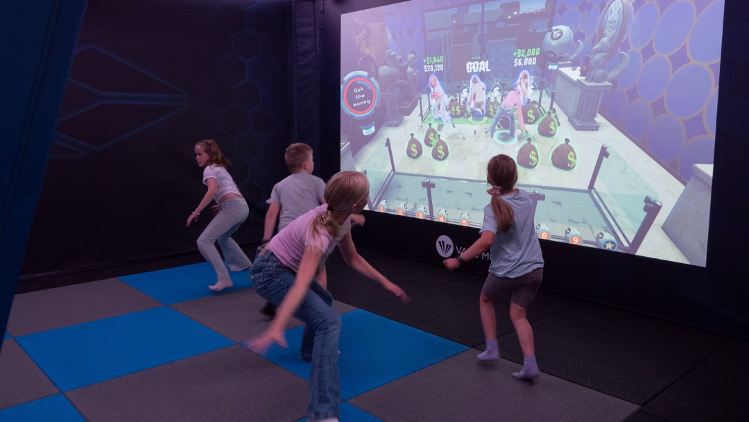 Four kids playing Operation Money Grab inside ValoArena 4-player.