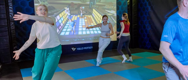 Two adults playing Party Box with two teenagers in ValoArena