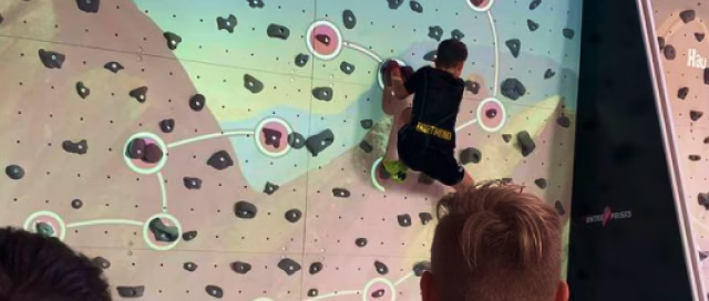 Child climbing Augmented Routes at a climbing gym on ValoClimb.