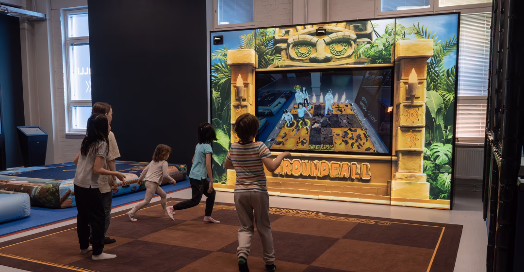 Five kids playing a mixed reality version of "floor is lava" on Groundfall.